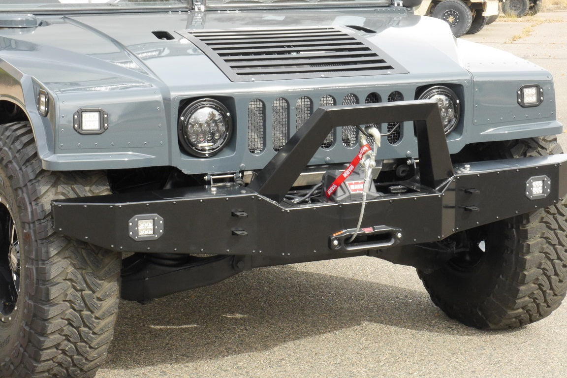 Black powdercoated heavy duty front bumper with a winch and LED fog lights for a humvee