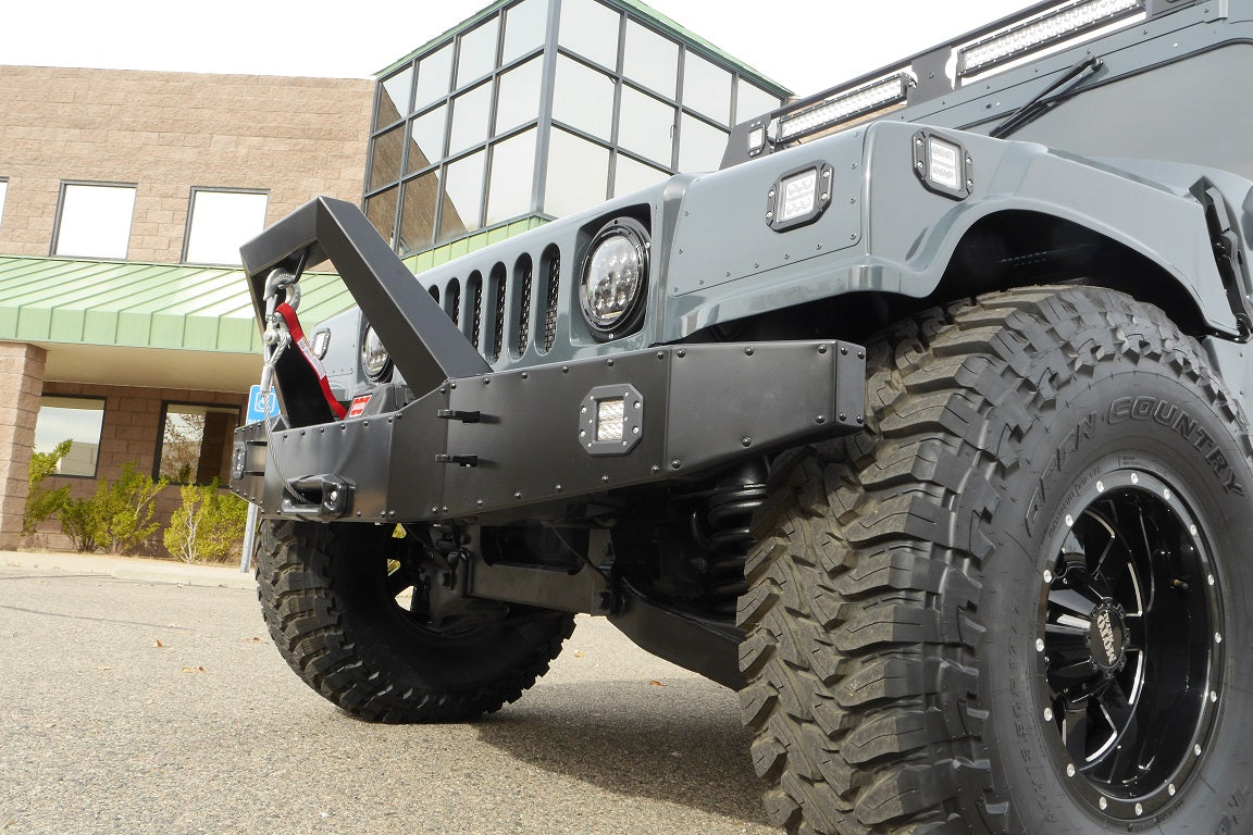 Black powdercoated heavy duty front bumper with a winch and LED fog lights for a humvee